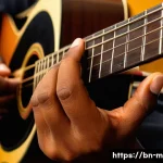 기타 코드표 사용법 - A detailed close-up of a Bengali musician&rsquo;s hands playing an acoustic guitar, focusing on correct fi...